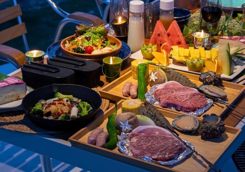 出云市Glamping Base IZUMO "Lakeside Hot Spring Hotel Kun - Vacation STAY 42014v的一张桌子上有很多种不同的食物