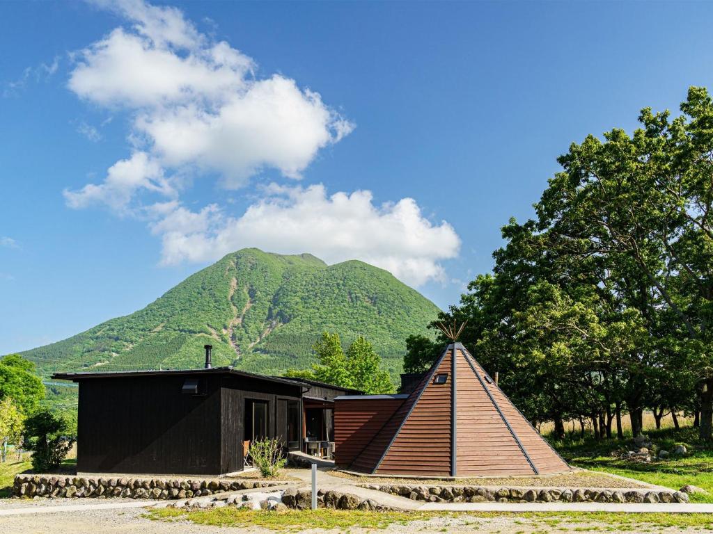 由布市Sense of wonder Yufudake Sanroku Glamping Resort - Vacation STAY 41963v的一座小房子,后面有山