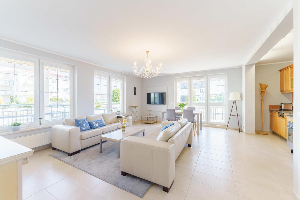 格里兹鲍AM Seaside - Apartament的大型客厅配有白色家具和窗户。