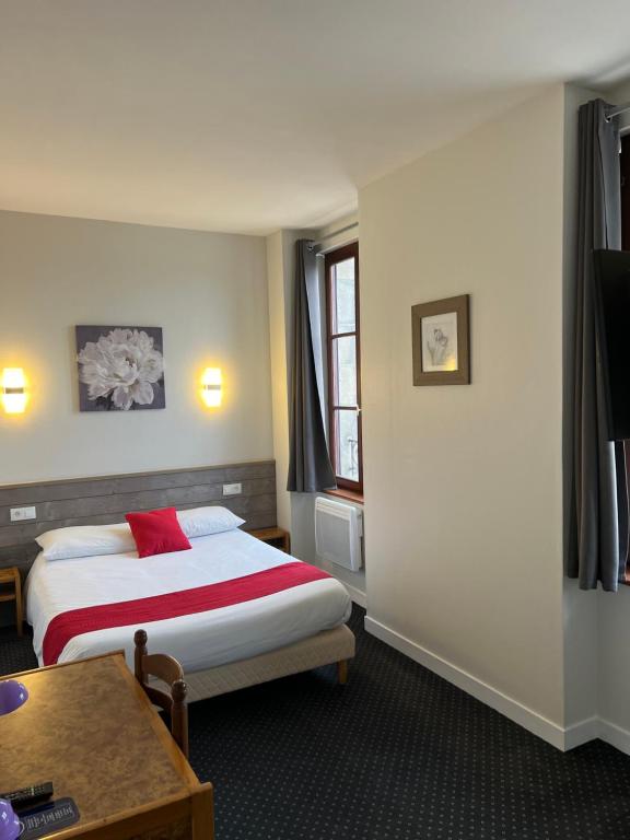 坎佩尔TGV酒店的酒店客房配有一张床铺和一张桌子。