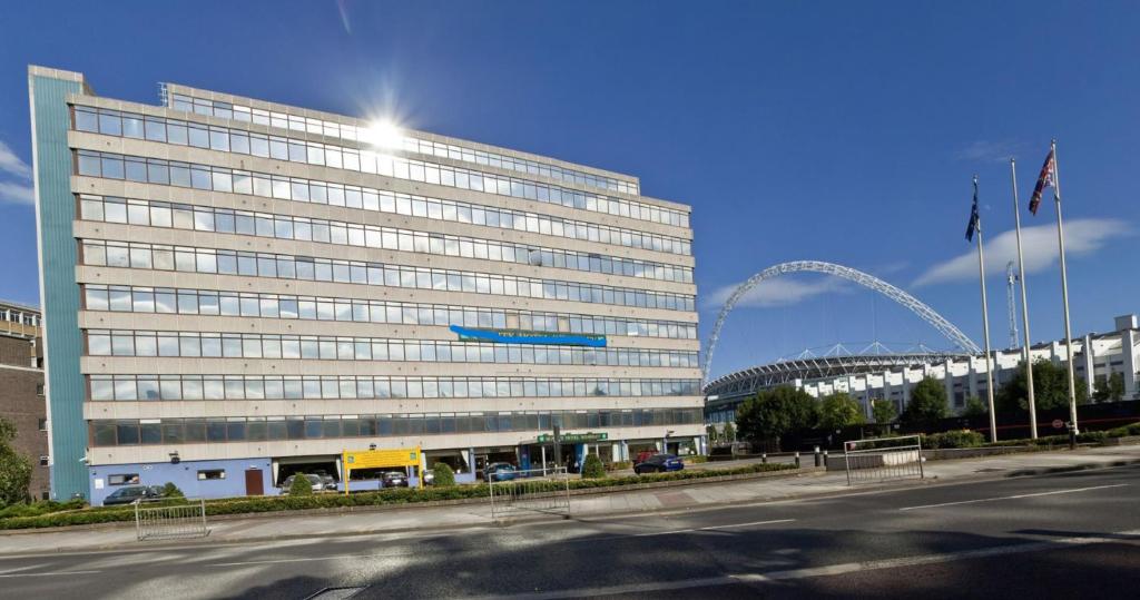 伦敦伦敦 - 温布利国际酒店的一座大型办公楼,上面有一架蓝色飞机
