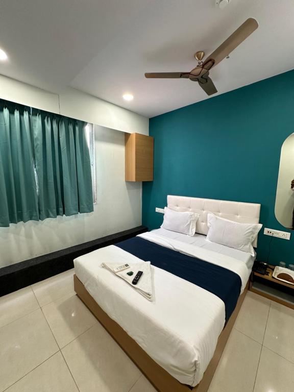 苏拉特Hotel sky palace adajan的一间卧室设有一张蓝色墙壁的大床