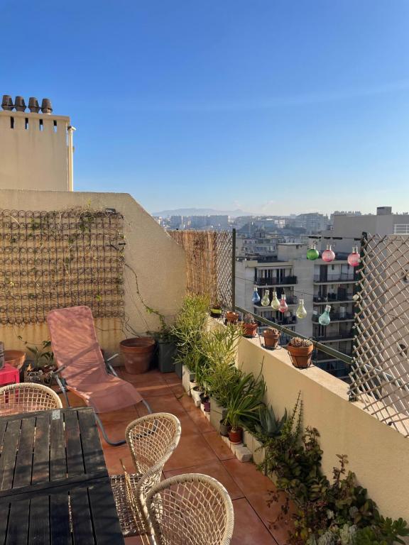 马赛Appart 60 m2 avec terrasse 35m2 séjour sud et 2 vraies chambres gare Saint-Charles的阳台的天井配有椅子和植物