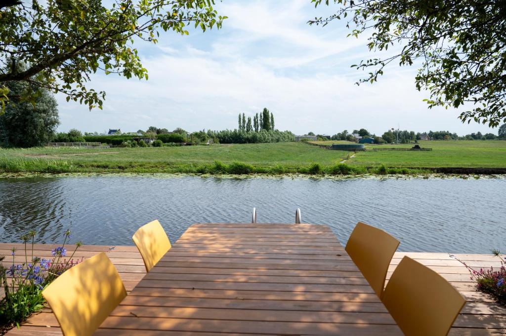 Roelofarendsveen5 persons Holiday Home Comfort的湖上带椅子的木甲板