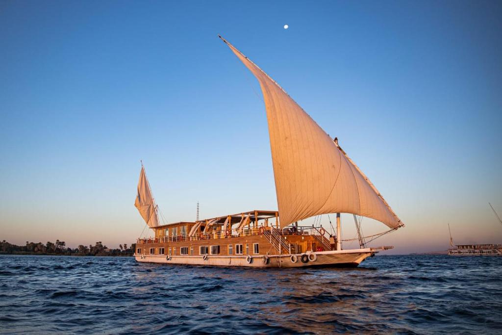 卢克索Dahabiya Akhnaton Every Monday from Esna to Aswan for 4 Nights的一艘在水中航行的船