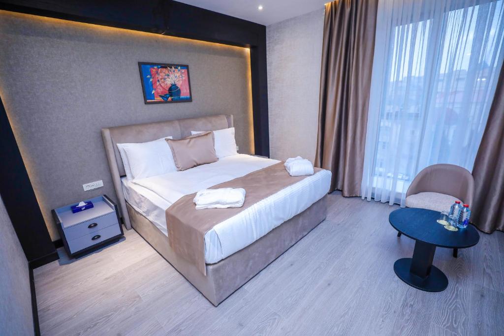 巴库Arium Hotel Baku的配有一张床和一把椅子的酒店客房