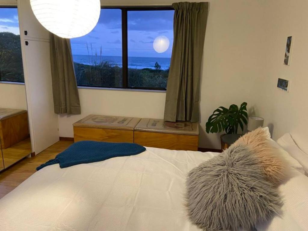BrightonOcean Retreat的一间卧室设有一张大床和一个大窗户