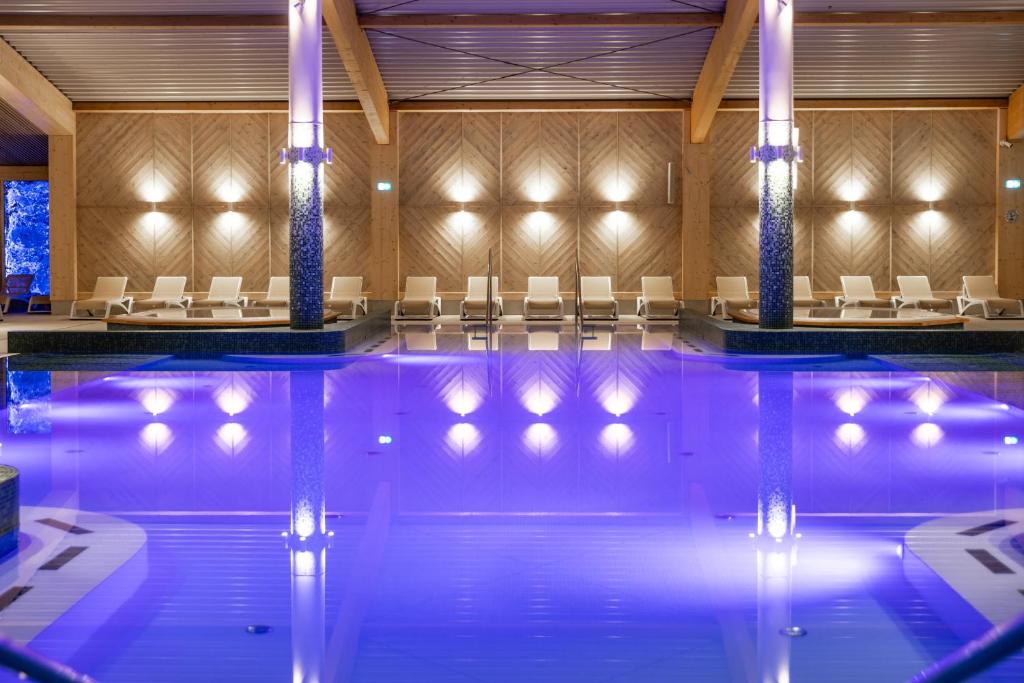 什切尔克Aries Hotel & SPA Szczyrk的一座带椅子的游泳池