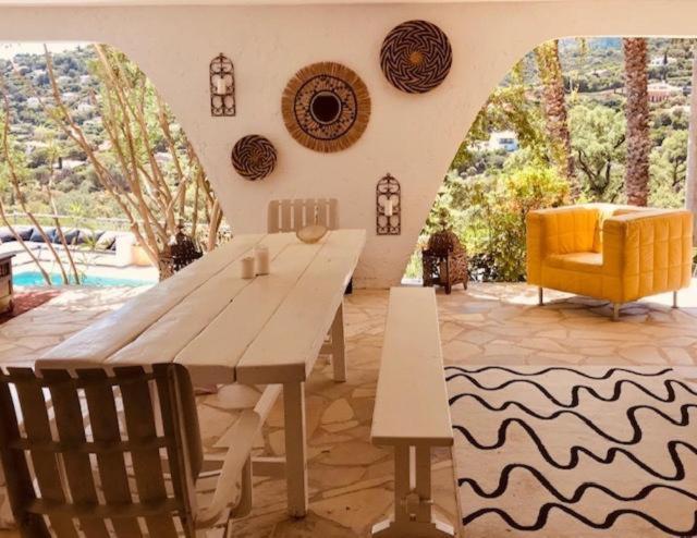 滨海卡瓦莱尔Villa Hirondelles 35的客厅配有木桌和黄椅