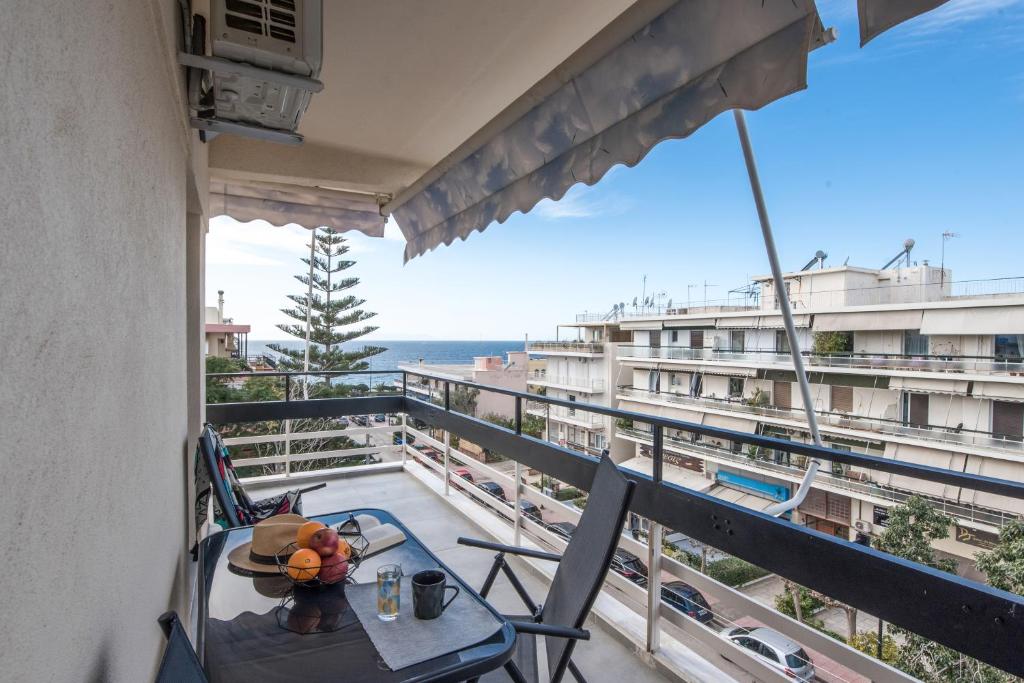 雅典Valeria's Sea View Apartment的阳台配有桌椅,享有海景。