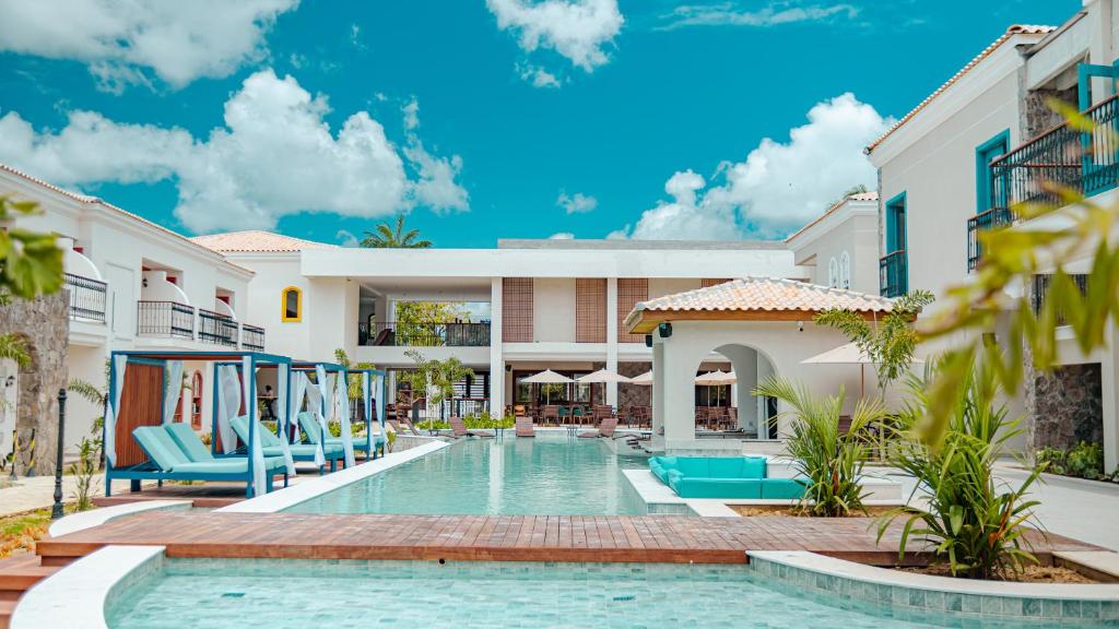 伊塔卡雷Resende Imperial Hotel & Spa的度假村内的游泳池,带蓝色椅子