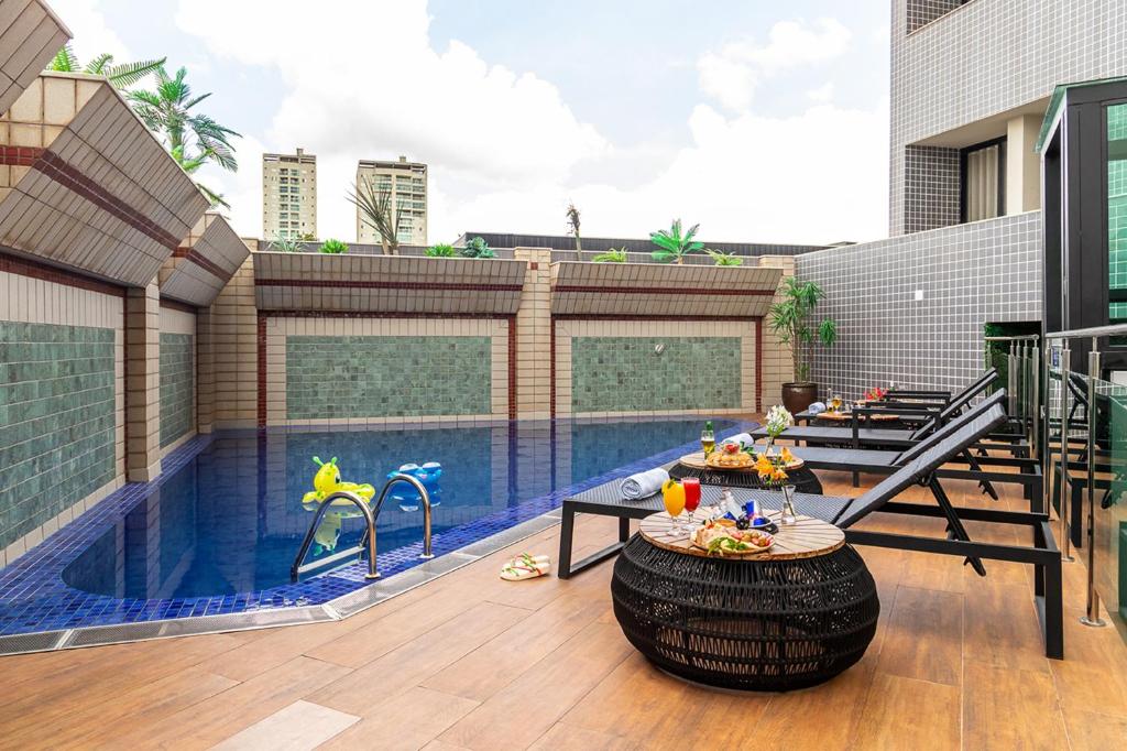 乌贝兰迪亚Hotel Dan Inn Uberlandia的庭院设有带桌子的游泳池和游泳池