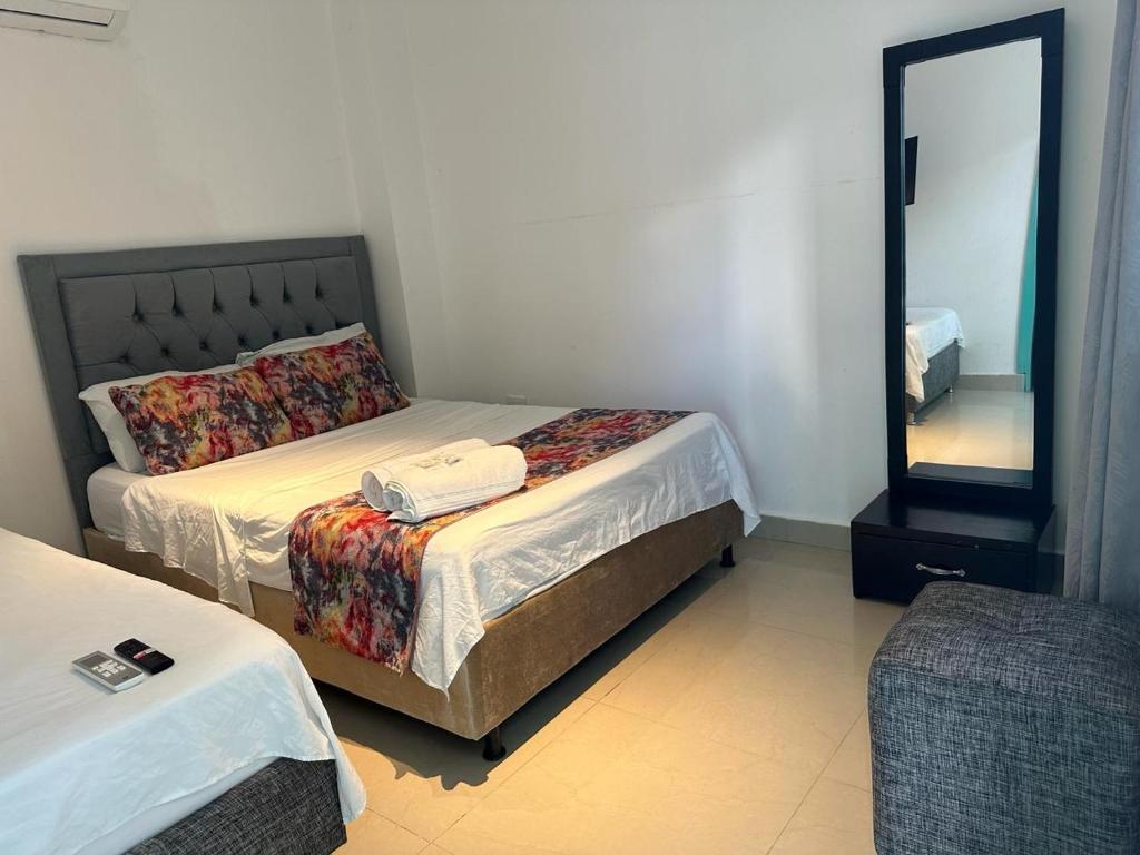 卡塔赫纳Hotel CastilloMar的一间卧室配有两张床和镜子