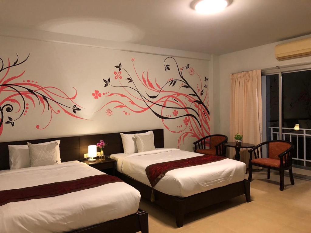 Ban Ko KwangNAKA GUEST HOUSE的一间卧室配有两张床,并装饰有鸟儿画