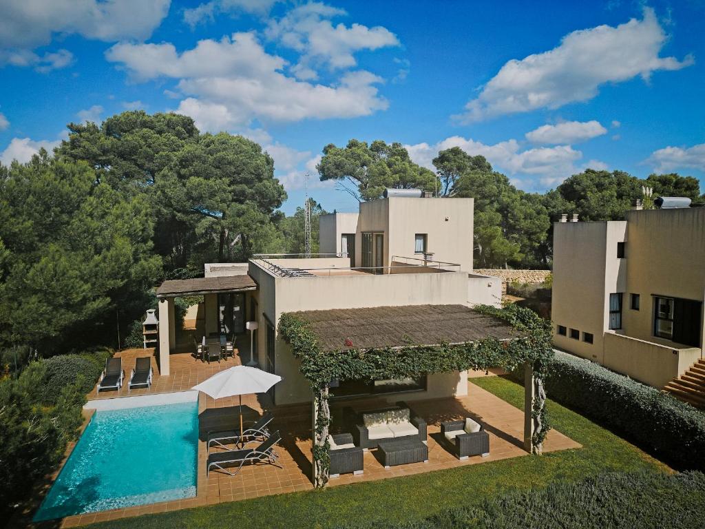 卡拉加尔达纳Prinsotel Villas Cala Galdana的享有带游泳池的房屋的空中景致