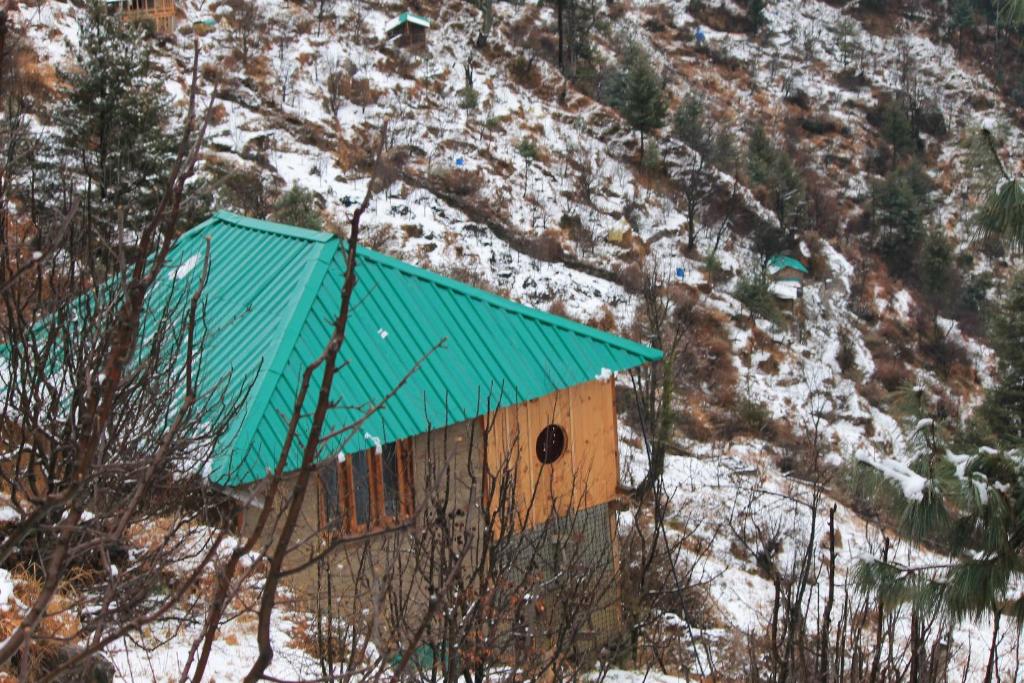 卡索尔Nomind Vibe的雪中带绿色屋顶的小房子