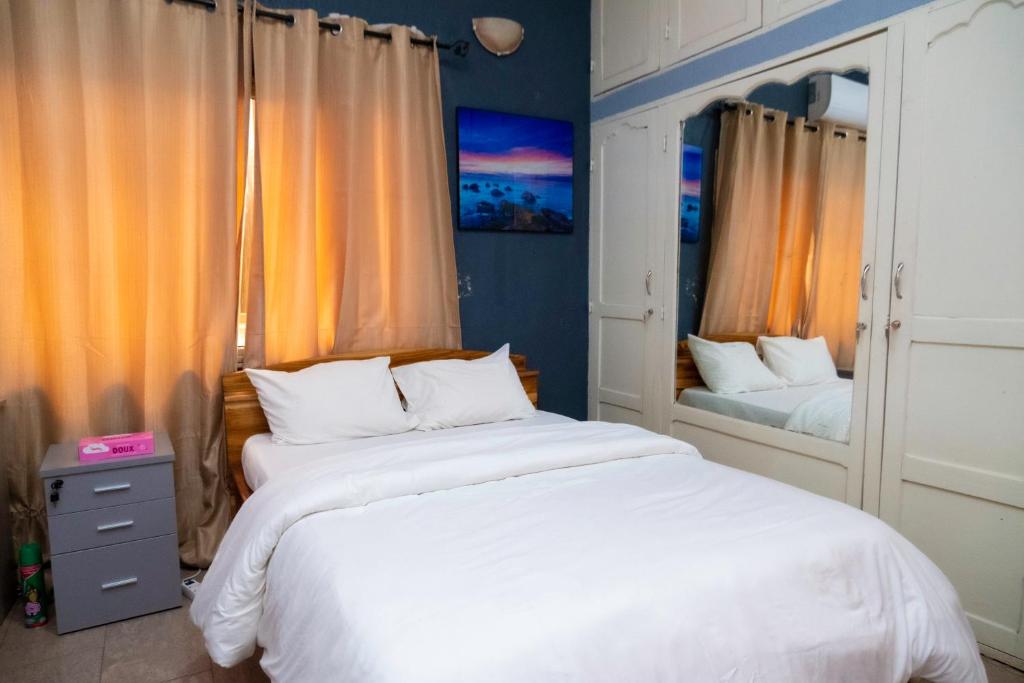 洛美Studio cosy climatisé的一间卧室设有两张床和两个窗户。