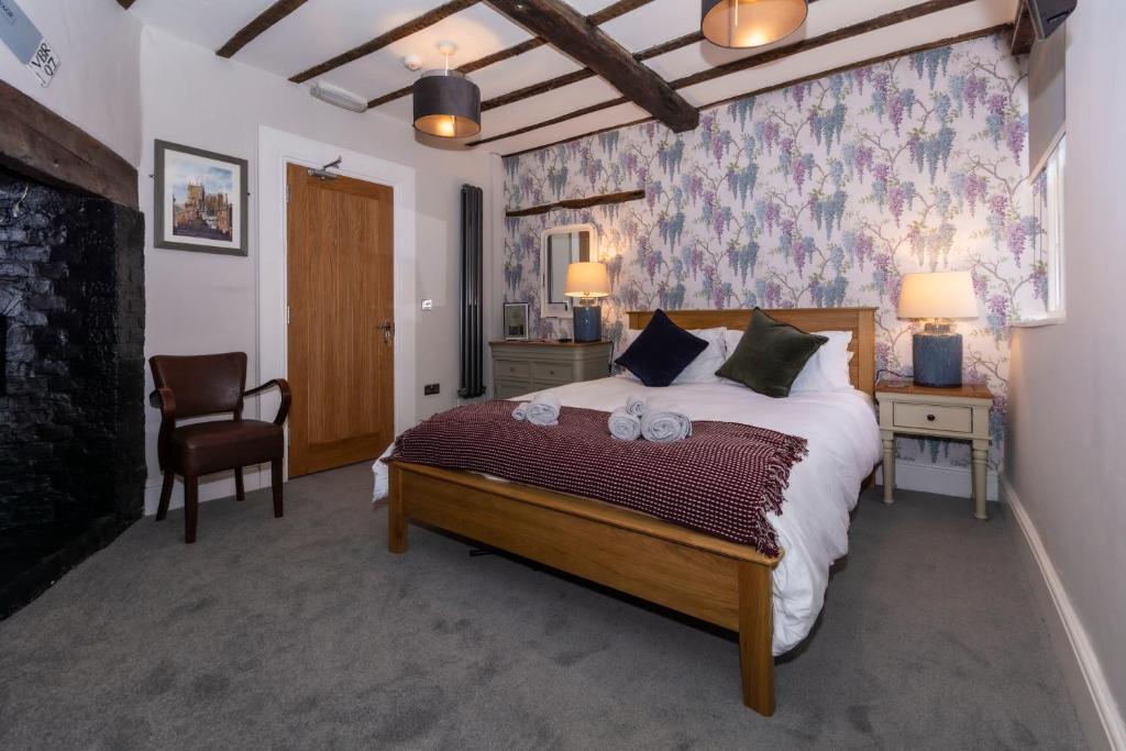 布由德利The Clockhouse Bewdley的一间卧室配有一张大床和一把椅子