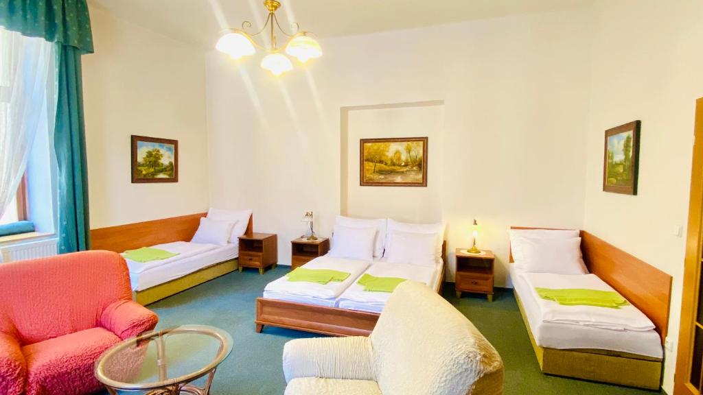 赫拉德茨 - 克拉洛韦塞尔尼昆膳食公寓的一间设有两张床、一张沙发和一把椅子的房间