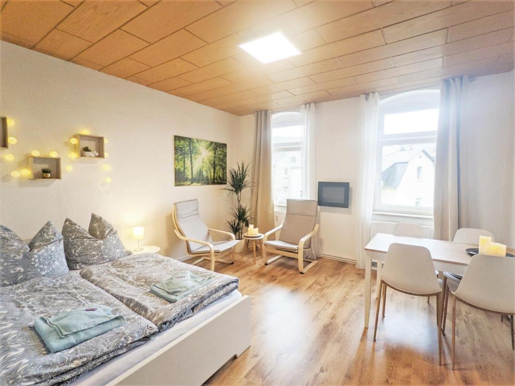 RathmannsdorfUrlaubsmagie - Helle Wohnung mit Garten & Pool - R3的卧室配有一张床和一张桌子及椅子