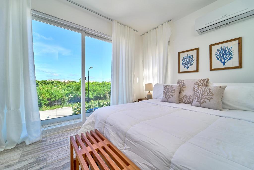 蓬塔卡纳Cana Brava Residences-Comfort Condo的一间卧室设有一张大床和一个大窗户