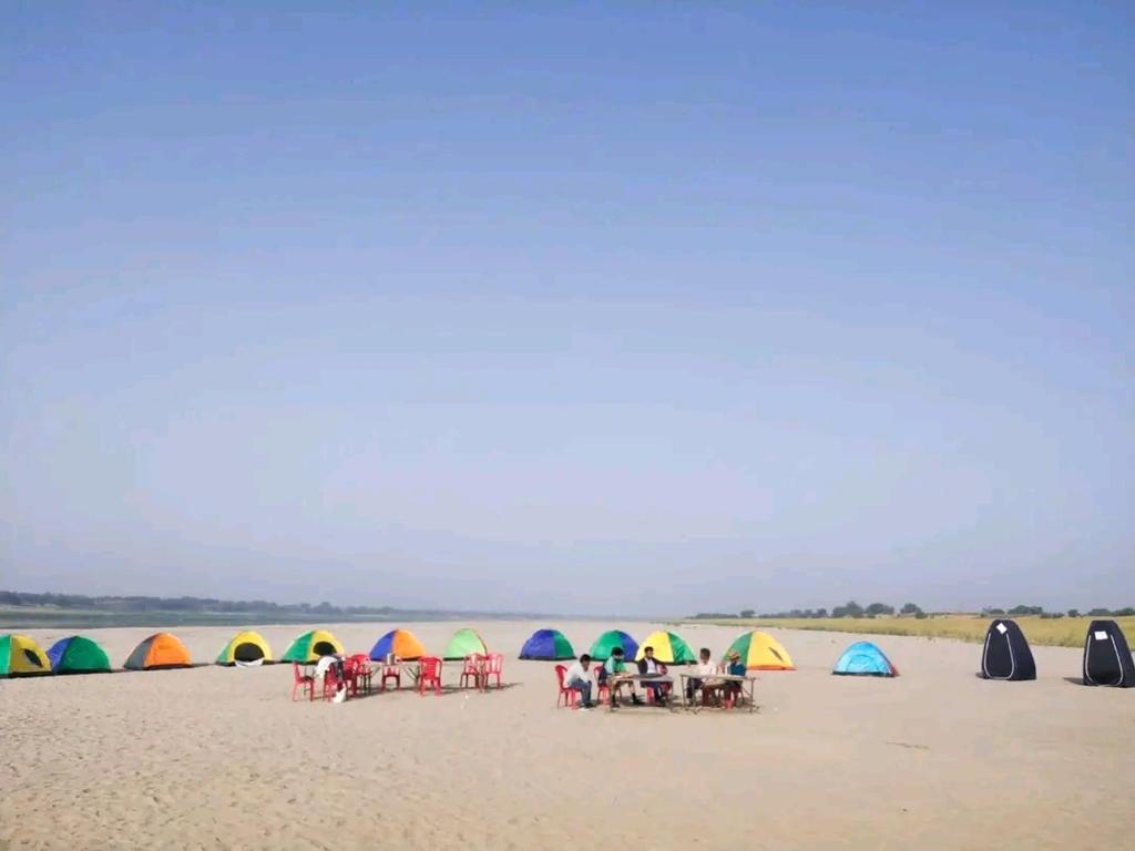 AuraiyaPachnad Camping And Water Sports Adventure的一群人在海滩上,有帐篷