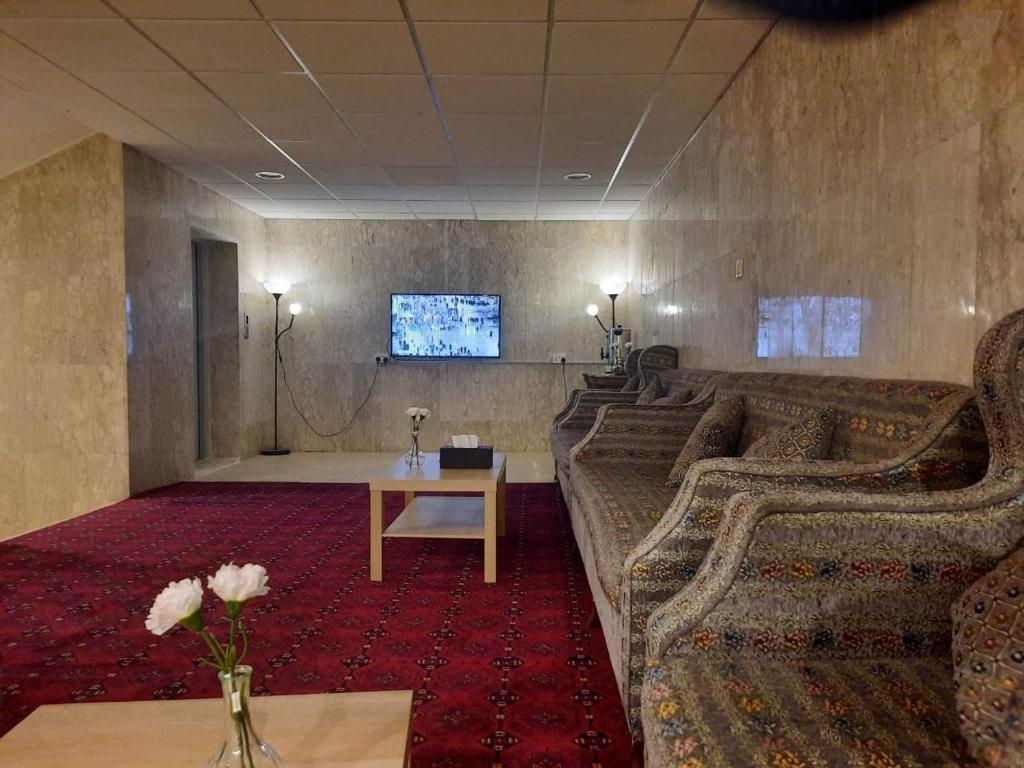 达曼الساعه 60 الفندقيه的带沙发、桌子和电视的客房