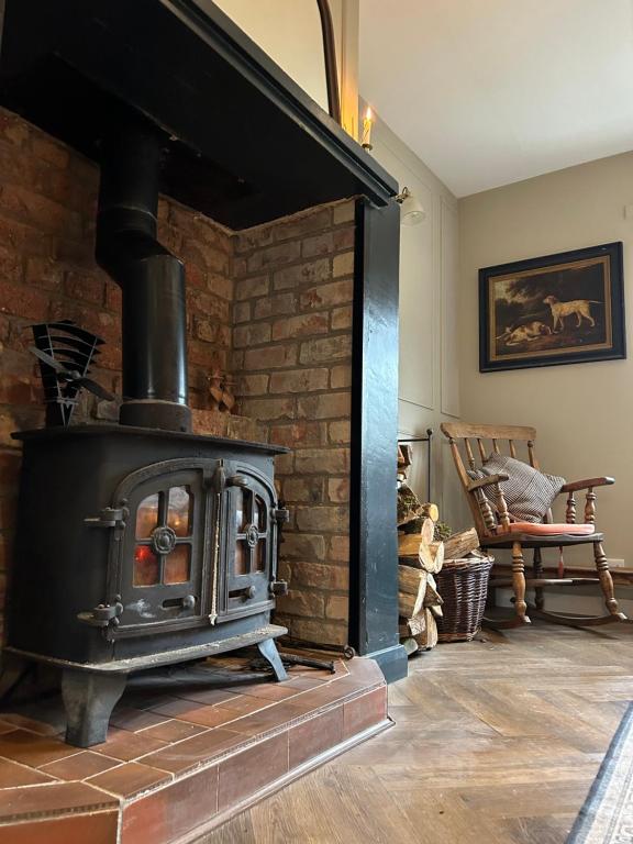 DerrygorryFavour Royal Cottage - dog friendly forest escape的客房内的砖砌壁炉与炉灶