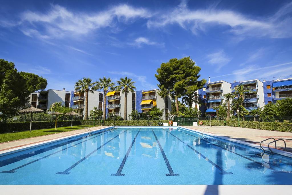 维拉福林New Reus Mediterrani的一个空的游泳池,有公寓楼,位于后面