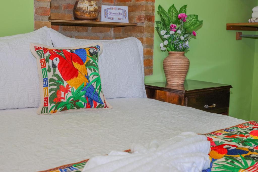 科潘玛雅遗址Hotel Itzae的配有枕头和花瓶的床