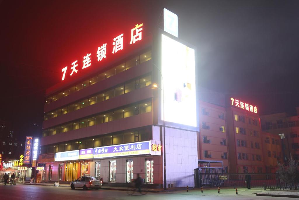 大同7天连锁酒店大同火车站店的一座大型建筑,旁边设有 ⁇ 虹灯标志