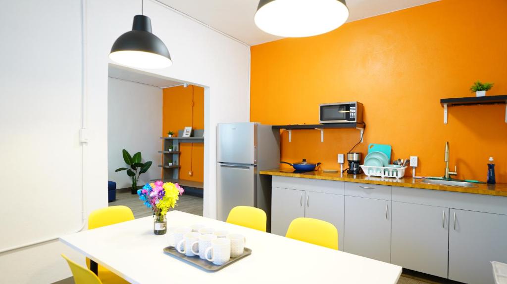 卡罗利纳Caribbean Stars的厨房设有橙色墙壁、桌子和冰箱