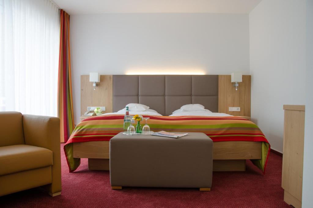 奥尔登堡Hotel Wieting的配有床、椅子和桌子的酒店客房