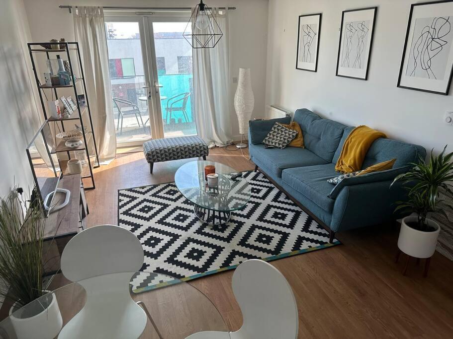 巴尔金Beautiful East London Flat的客厅配有蓝色的沙发和桌子