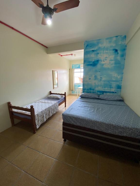 瓜尔达恩巴Pousada Vera Lucia的一间卧室配有两张床和吊扇