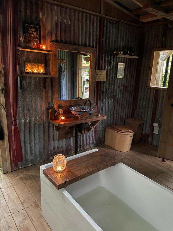 莱文The kauri Tree Pod - Off Grid Experience的带浴缸和木桌的客房