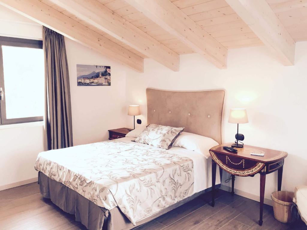 坎图La Villa Bianca Guest house的一间卧室配有一张床、一张桌子和一个窗户。