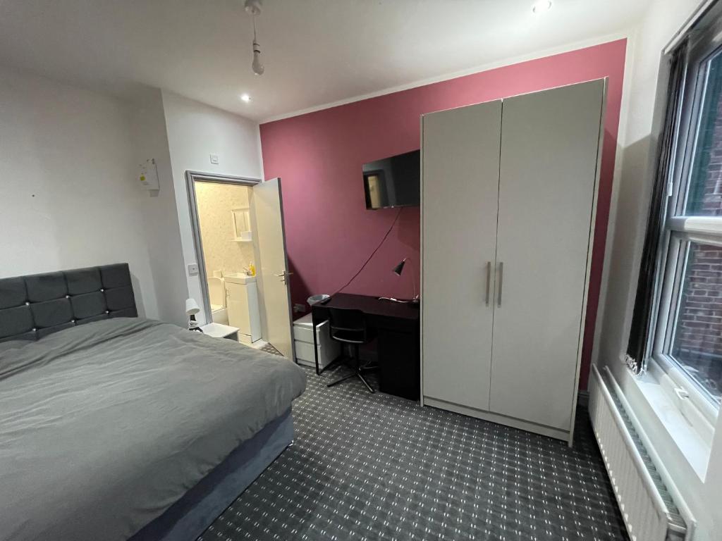 曼彻斯特Luxurious En-suite Room 3的一间卧室配有一张床和一张书桌