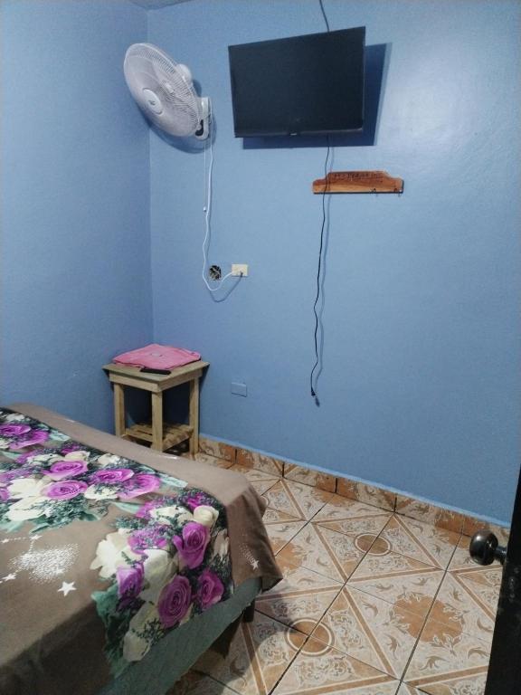 科马亚瓜Hotel 24 /7的一间设有床铺和墙上电视的客房