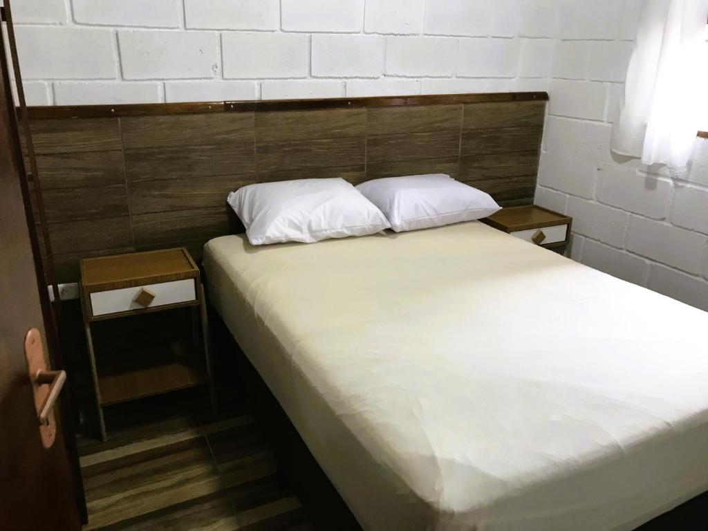 卡拉瓜塔图巴Villaggio Miravela的床上有2个白色枕头