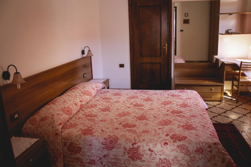 弗卢米尼马焦雷Agriturismo Perdaba的一间卧室配有一张带红色花卉床罩的床。
