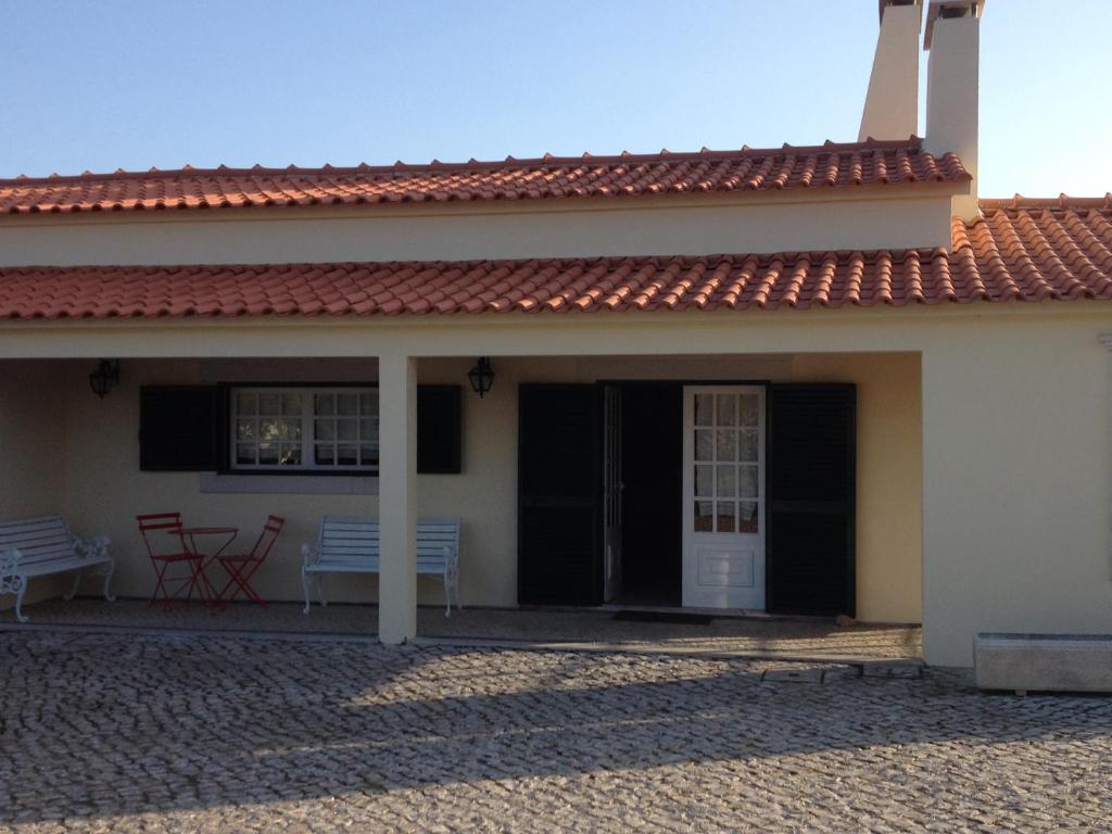 塞图巴尔Casa do Jardim的白色的房子,设有门廊和长凳