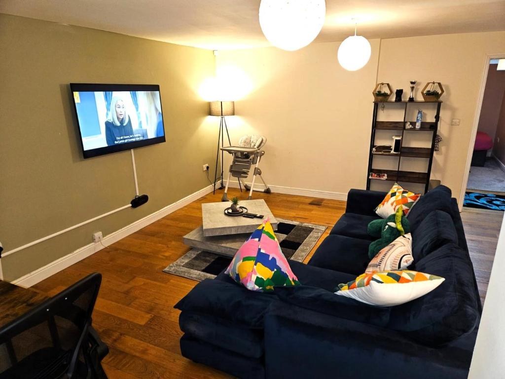 伦敦London O2 ARENA COOL BREEZE HOUSE的客厅配有蓝色的沙发和平面电视。