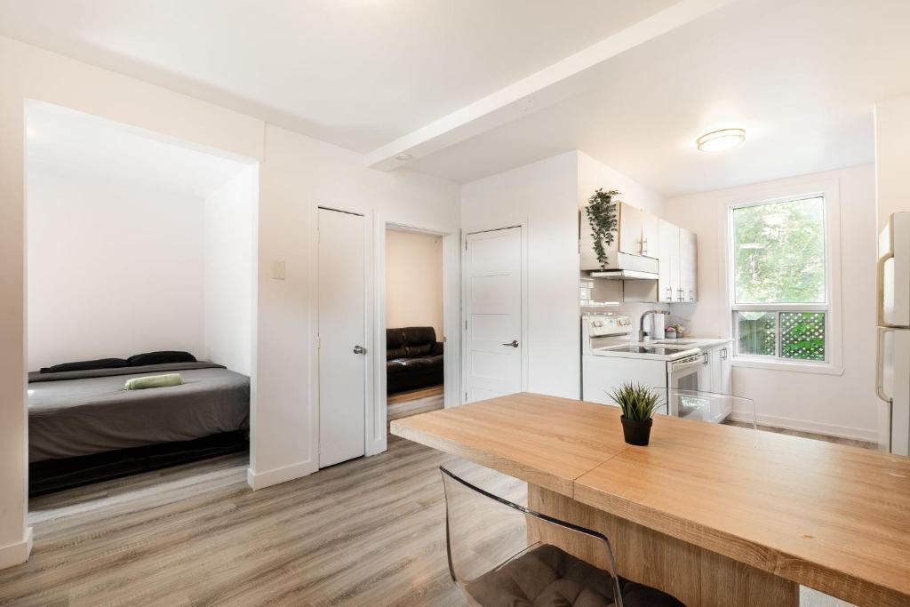 蒙特利尔Appartement 1 chambre-1011的白色的客房配有桌子和床。