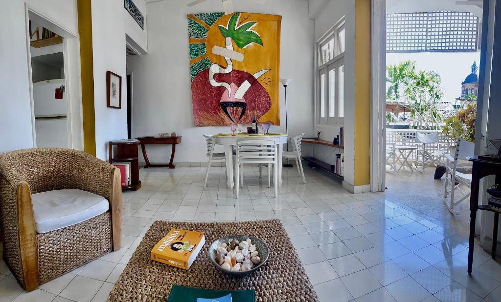 卡塔赫纳Bello apartamento corazón de Cartagena colonial的客厅配有桌椅和绘画作品