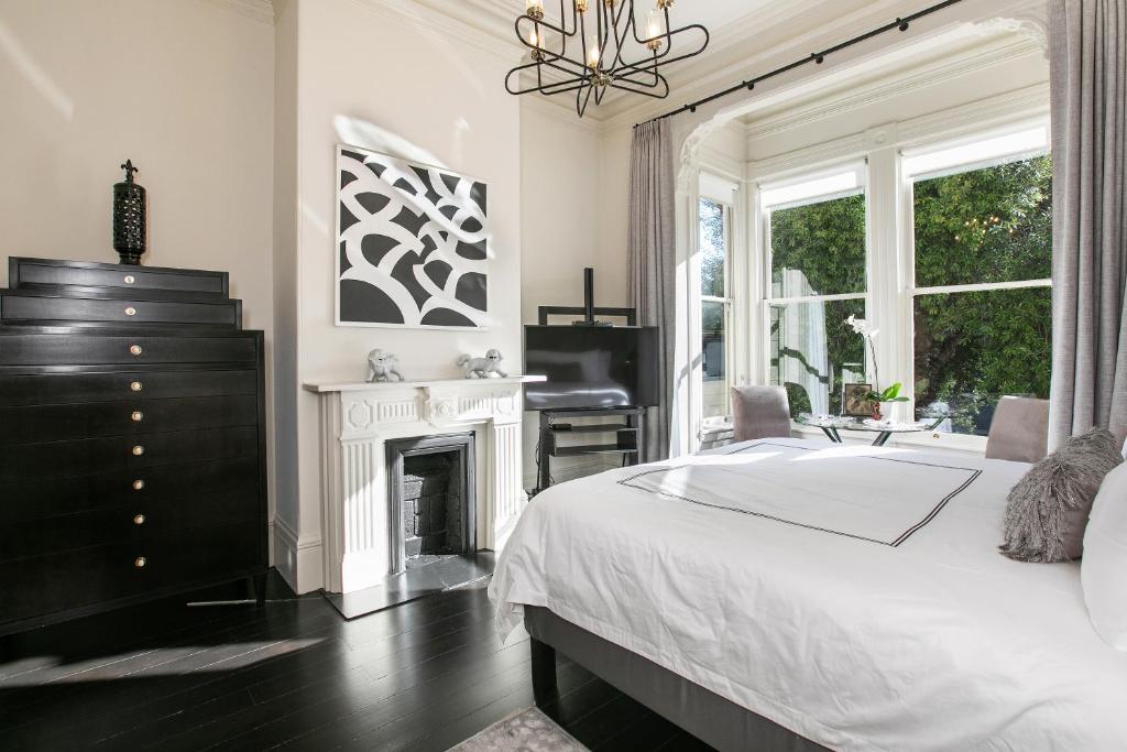 旧金山Pacific Heights Grand Elegant Studio的一间卧室配有一张床、一个壁炉和一个梳妆台