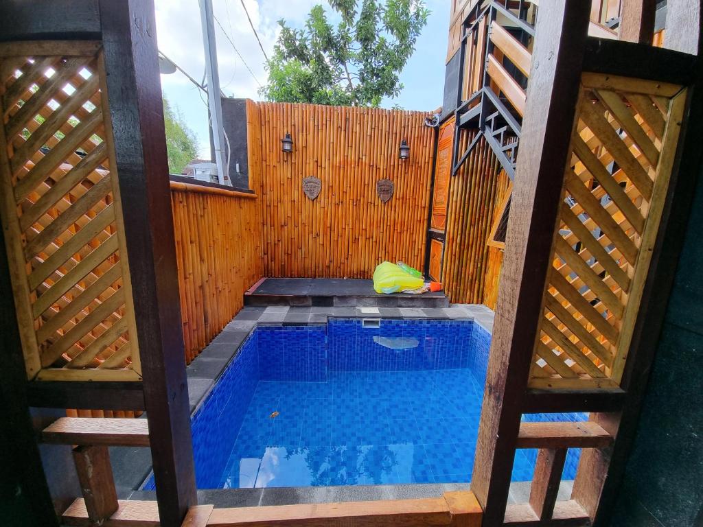 马塔兰Suci's Friendly Appartment的后院的游泳池,带有木栅栏