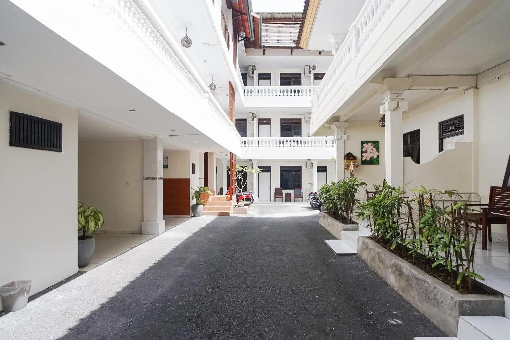 库塔巴厘岛城市花园德维帕酒店的一条有植物的建筑的空走廊