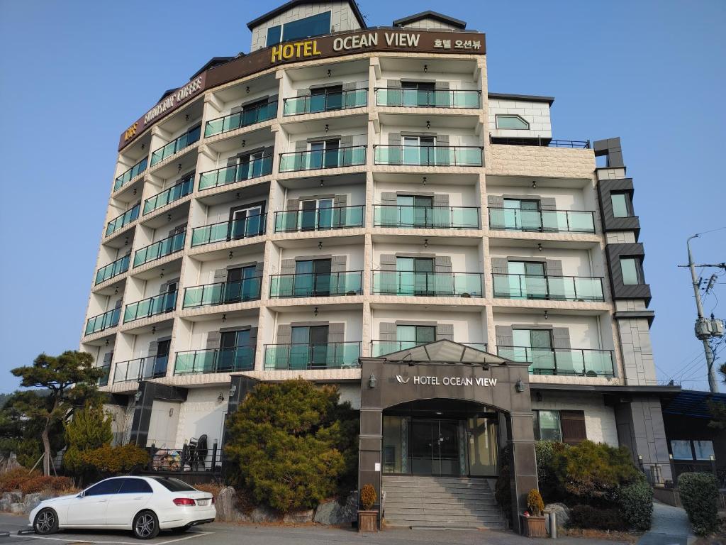 仁川市Hotel Oceanview的停在大楼前的白色汽车