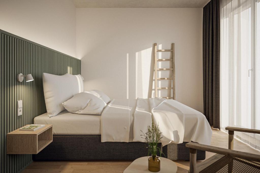卡罗利嫩西尔NOORD Carolinensiel的一间卧室配有一张带白色床单和梯子的床。